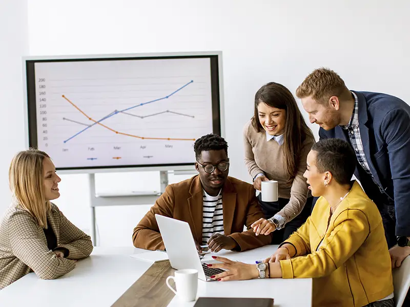 Uma equipe trabalhando em um escritório, analisando gráficos e dados